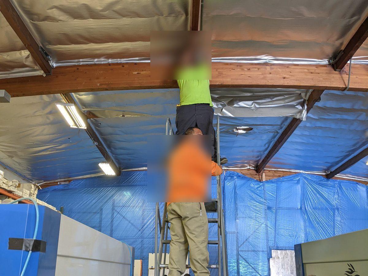 Electrician installing ceiling light fixtures in commercial space - AMY Electric
